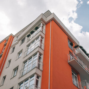 Immeuble moderne avec façade orange et balcons.