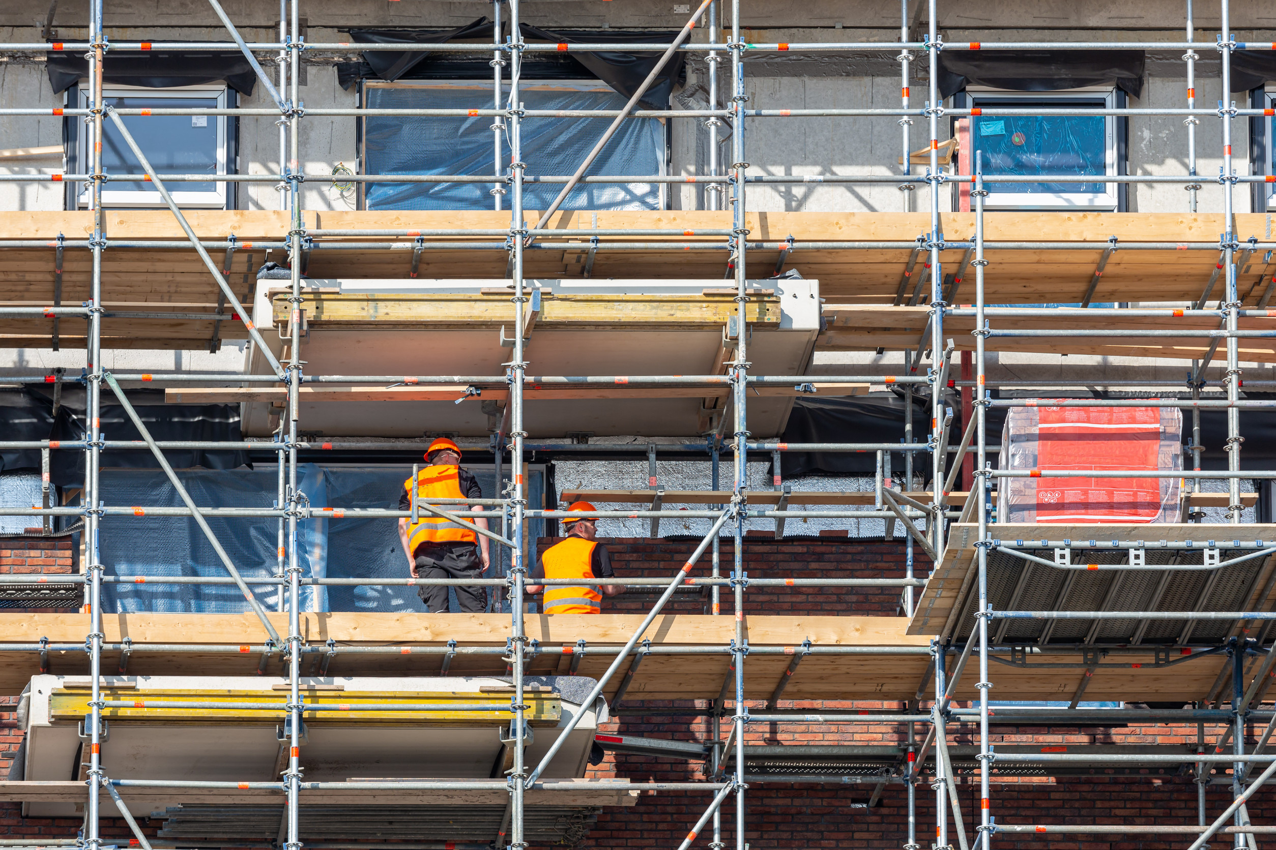 Ouvriers en construction sur échafaudage.